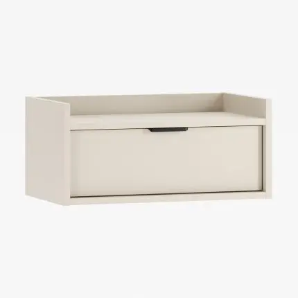 Nattbord SIGI i lys beige farge – vegghengt med svart håndtak og skuff i minimalistisk design.
